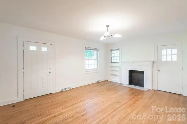 a view of empty room with a fireplace and window