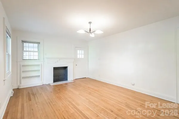 a view of a bedroom with wooden floor and cabinet