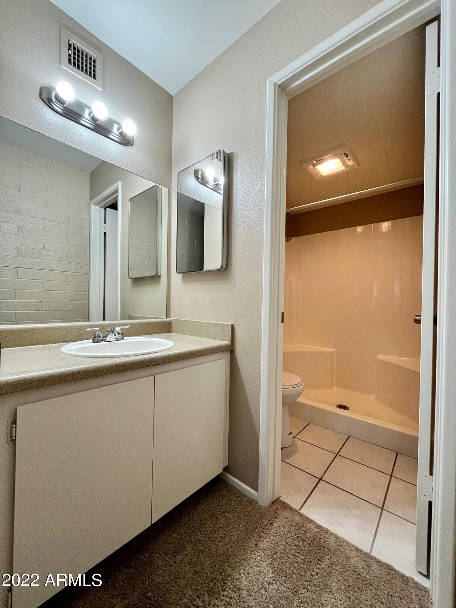 1701 West Tuckey Lane, Unit 225 Phoenix, AZ 85015 - Photo 8 of 13 a bathroom with a double vanity sink a large mirror and shower