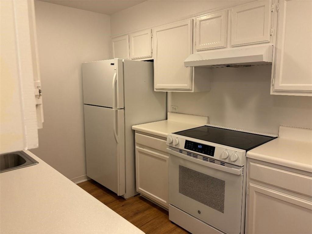 145 15th Street Northeast, Unit 1007 Atlanta, GA 30361 - Photo 13 of 14 a kitchen with white cabinets and white appliances