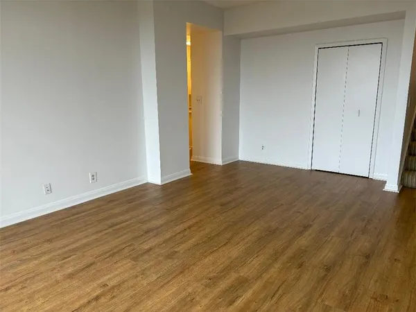 a view of an empty room with wooden floor