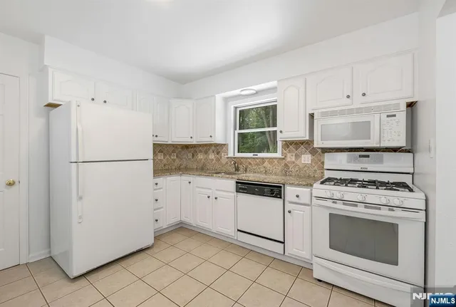 a kitchen with cabinets appliances and a window