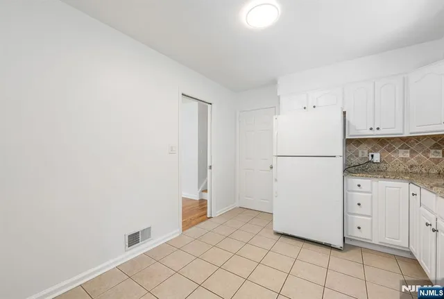 a kitchen with white cabinets and white appliances