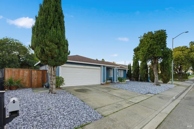 a front view of a house with a yard and potted plants