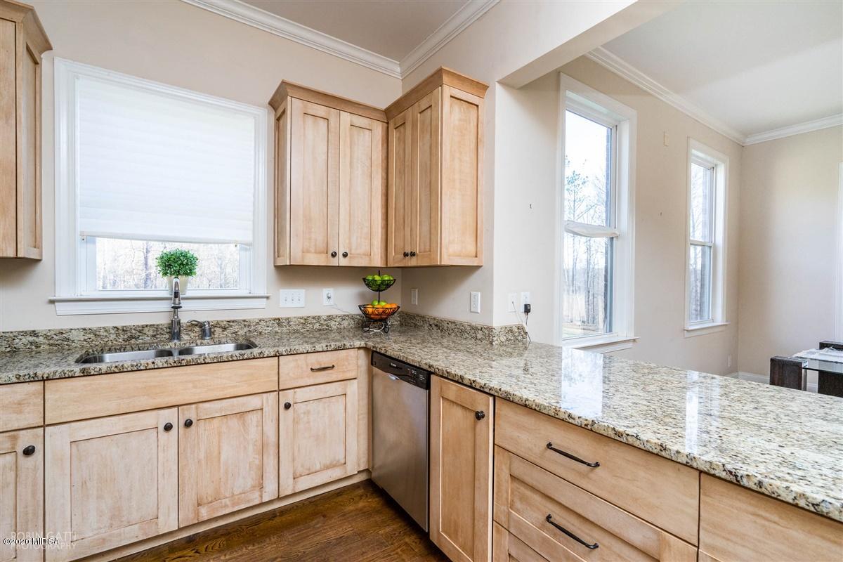 125 Raleigh Drive Forsyth, GA 31029 - Photo 8 of 37 a kitchen with granite countertop white cabinets and white appliances