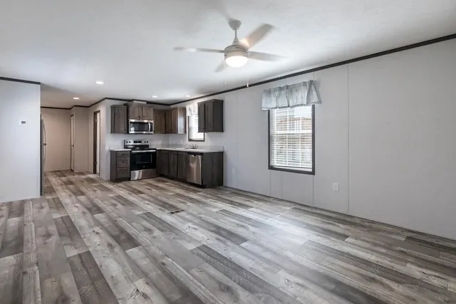 a large kitchen with kitchen island a stove a refrigerator cabinets and wooden floor