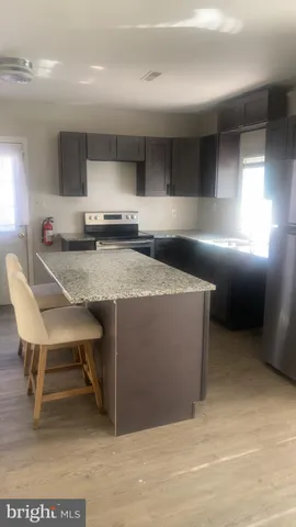 a kitchen with a sink cabinets and wooden floor