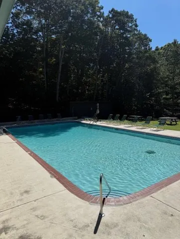 a view of a golf ground with large trees