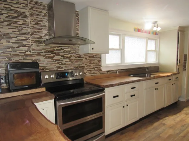 a kitchen with granite countertop white cabinets and appliances