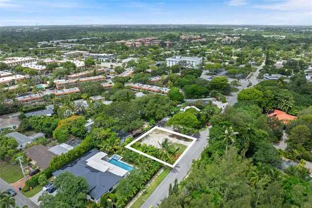 an aerial view of residential houses with outdoor space and trees