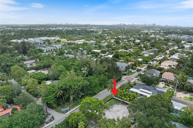 an aerial view of residential houses with outdoor space and trees