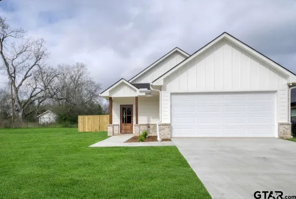 a view of a house with backyard and a garden