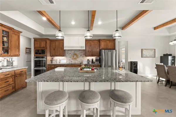 a kitchen with kitchen island granite countertop a sink and chandelier
