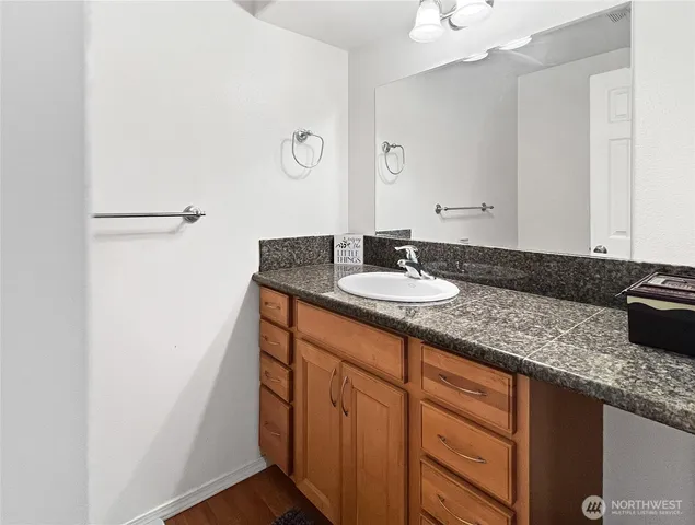 a bathroom with a granite countertop sink and a mirror