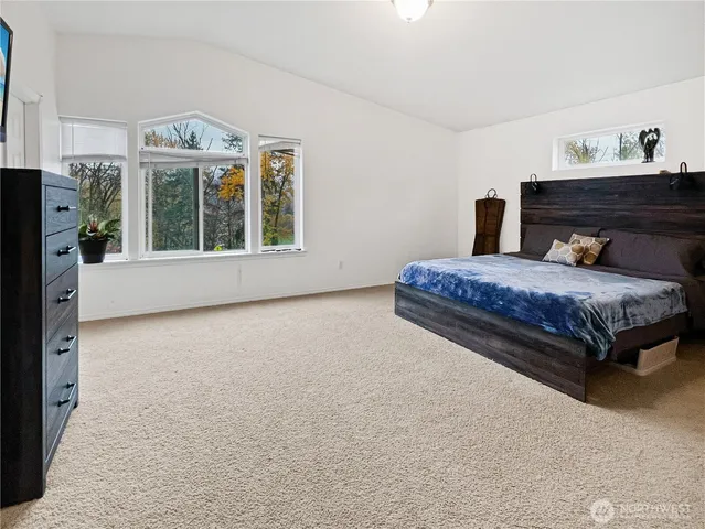 a spacious bedroom with a bed and a window