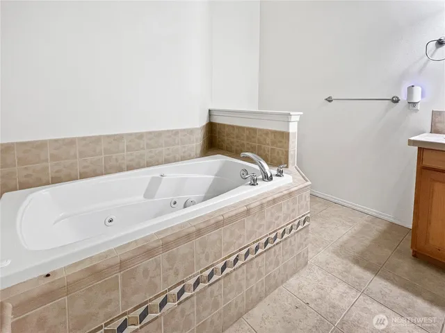 a spacious bathroom with a bathtub and mirror