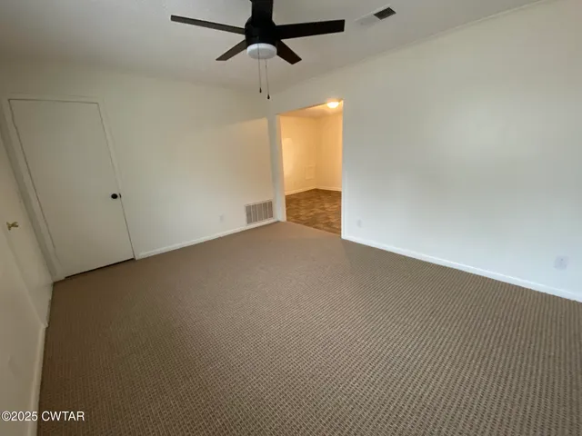 a view of an empty room and a ceiling fan
