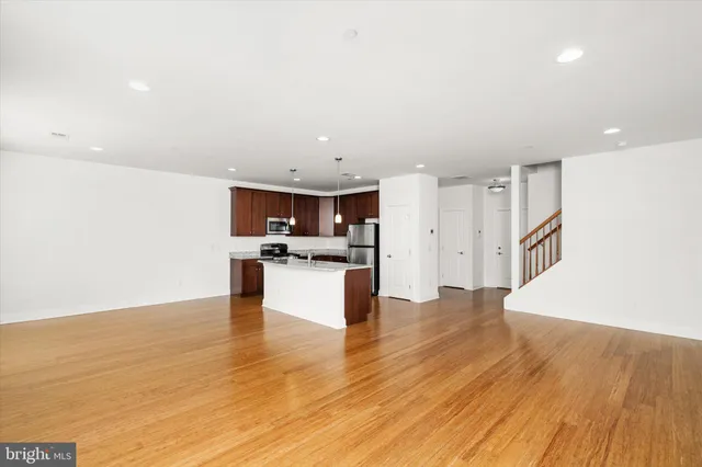 a view of kitchen with microwave refrigerator and cabinets