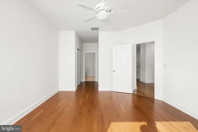 a view of an empty room with wooden floor