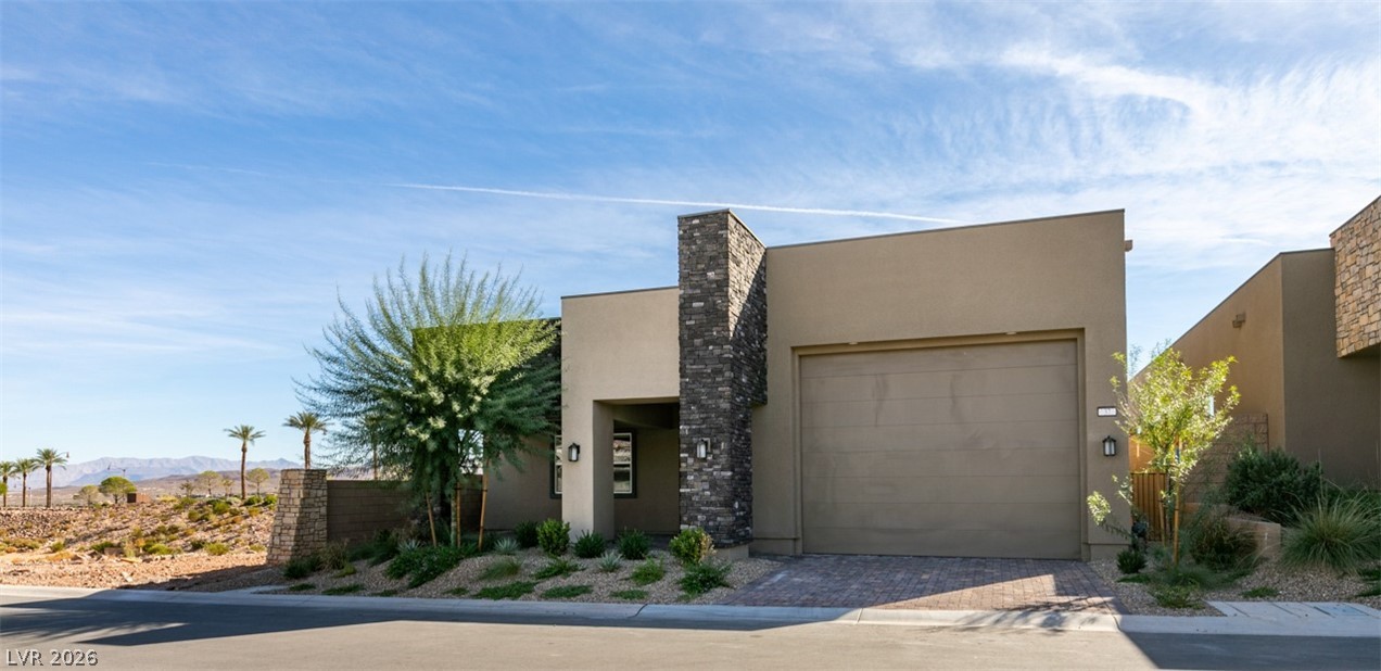37 Charlotte Ridge Place Henderson, NV 89011 - Photo 34 of 44 Modern desert home showcases sleek stucco, striking stone accents, and inviting landscaping.