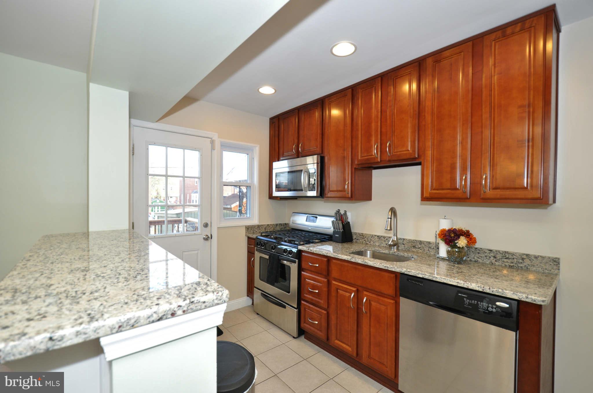 1921 Penhall Road Baltimore, MD 21222 - Photo 11 of 29 a kitchen with stainless steel appliances granite countertop wooden cabinets and sink