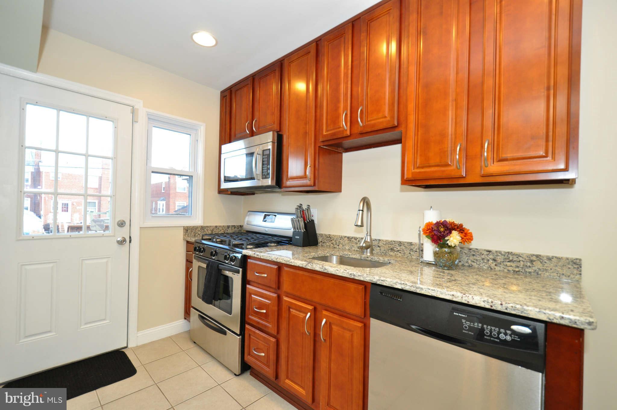 1921 Penhall Road Baltimore, MD 21222 - Photo 12 of 29 a kitchen with stainless steel appliances granite countertop a stove a sink dishwasher and a microwave oven with cabinets