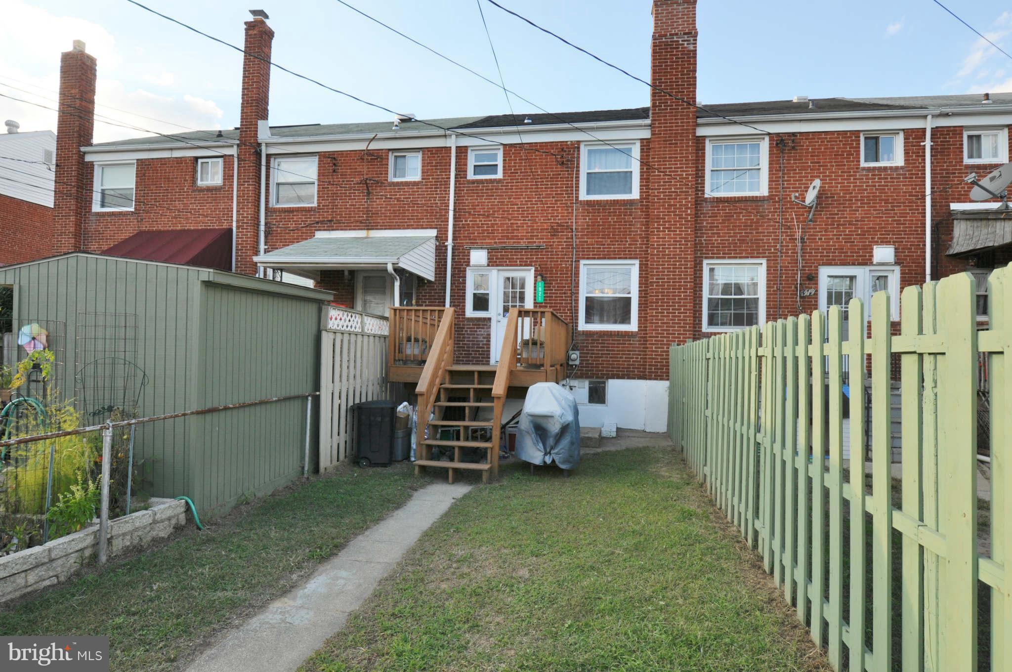 1921 Penhall Road Baltimore, MD 21222 - Photo 28 of 29 a view of a brick house with a yard and lawn chairs