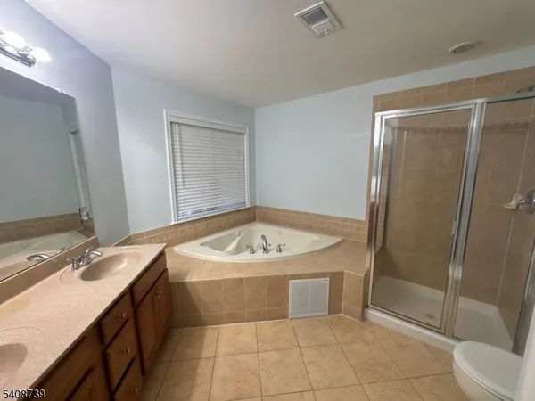 a bathroom with a sink a toilet a mirror and shower