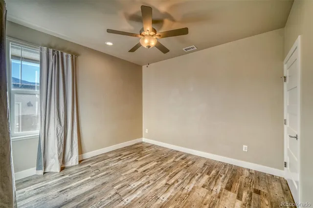 a view of a livingroom with a ceiling fan and wooden floor