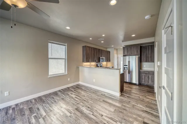 a view of empty room with wooden floor and window