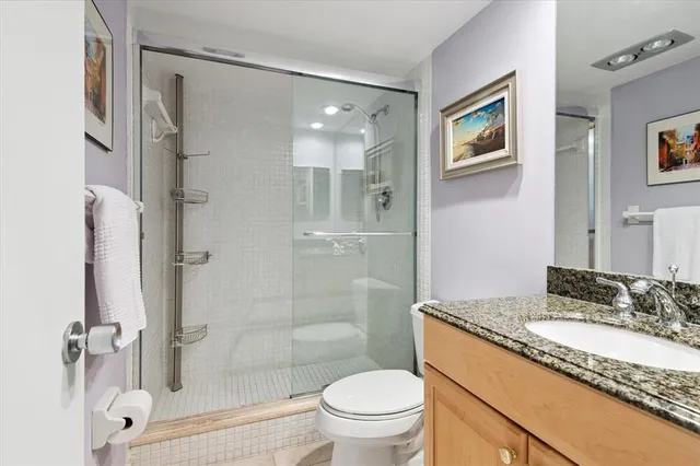 a bathroom with a granite countertop sink toilet and shower