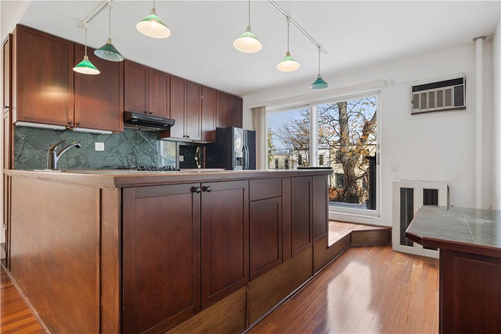 457 44th Street Brooklyn, NY 11220 - Photo 5 of 16 a kitchen with stainless steel appliances kitchen island granite countertop a refrigerator a oven a sink with island and chairs in it