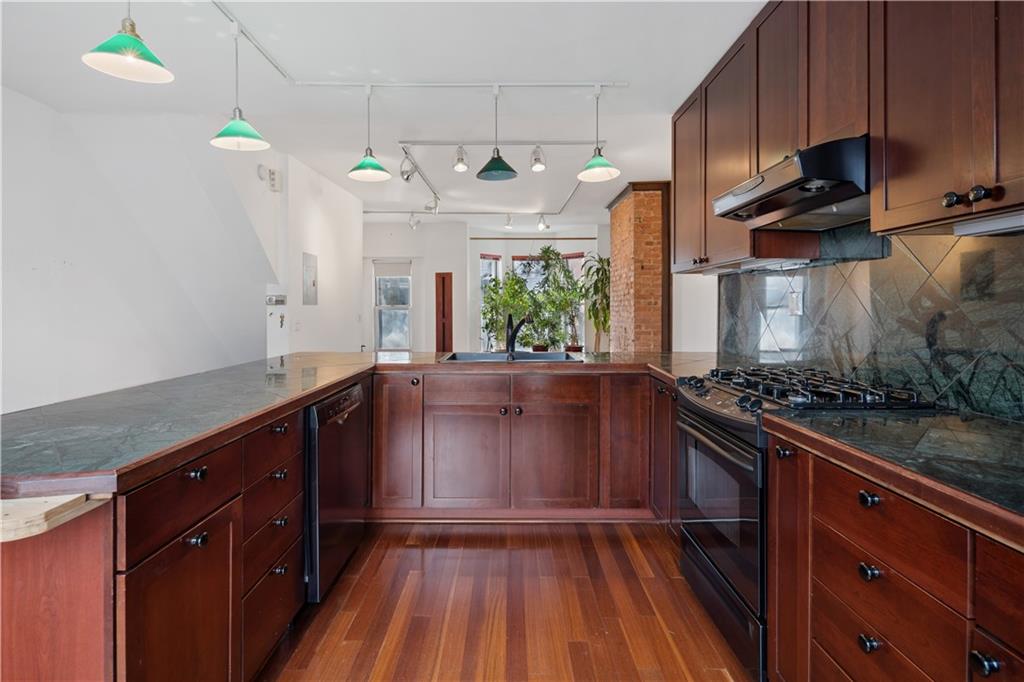 457 44th Street Brooklyn, NY 11220 - Photo 7 of 16 a kitchen with stainless steel appliances granite countertop a stove a sink and a wooden cabinets