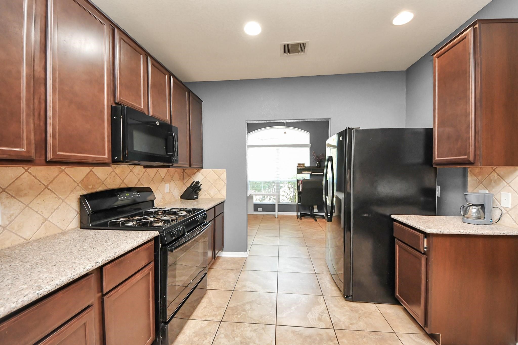 15003 Signal Ridge Way Cypress, TX 77429 - Photo 12 of 40 a kitchen with stainless steel appliances granite countertop a refrigerator a stove a sink and a microwave