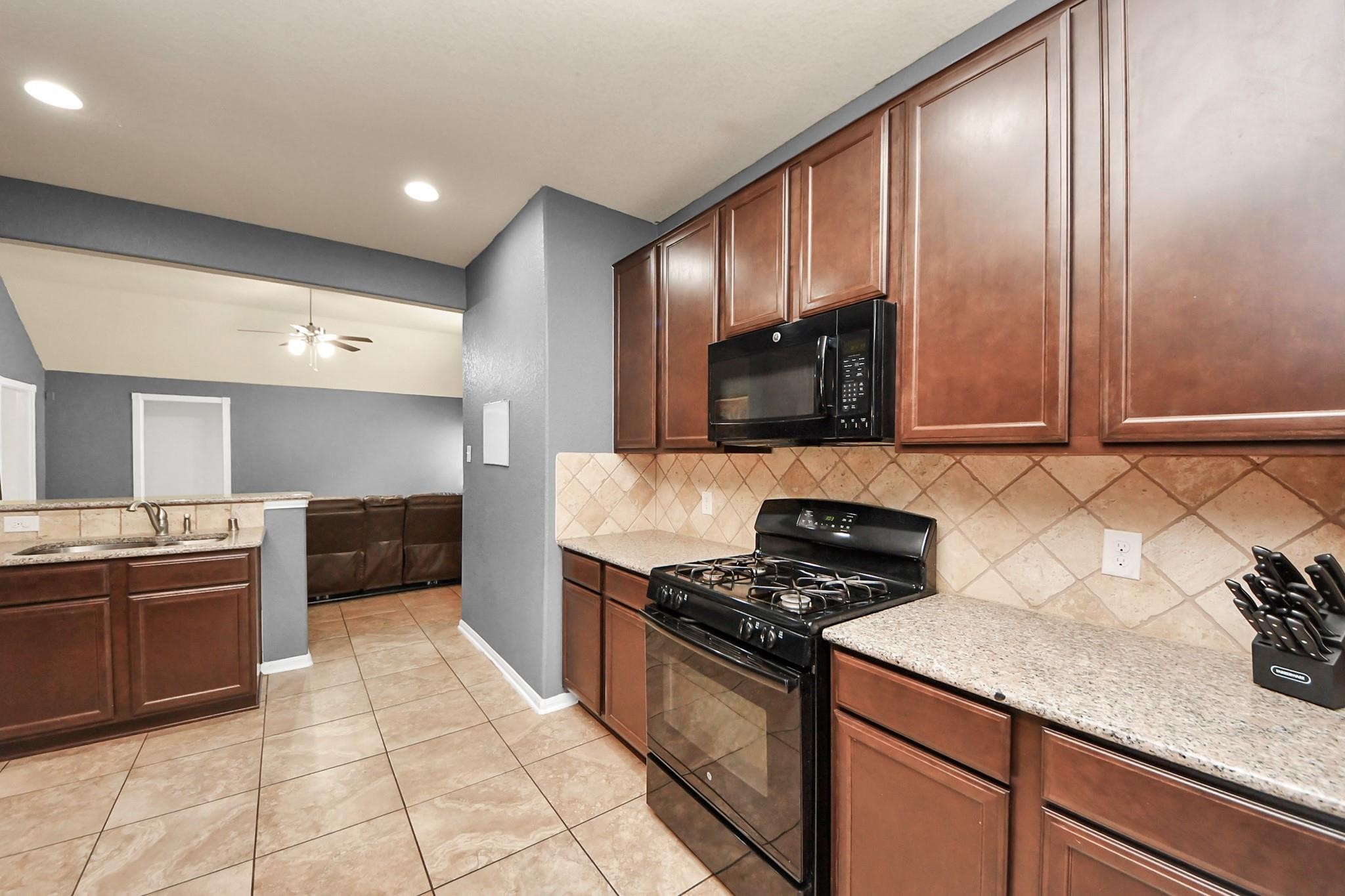 15003 Signal Ridge Way Cypress, TX 77429 - Photo 14 of 40 a kitchen with stainless steel appliances granite countertop a stove a sink and a microwave