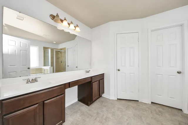 a bathroom with a double vanity sink and mirror