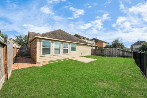 a view of a house with a big yard plants and large tree