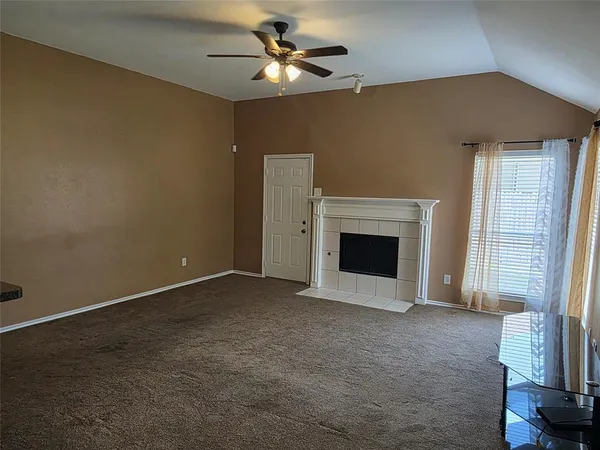 a view of an empty room with a fireplace and a window