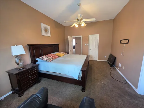 a bedroom with a bed and lamp on the dresser