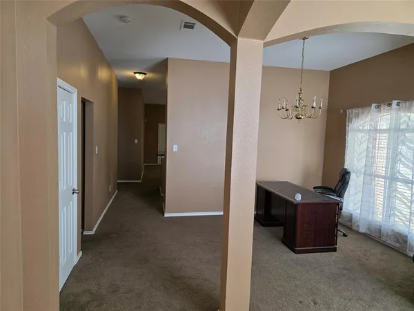 a view of a hallway with workspace and a window