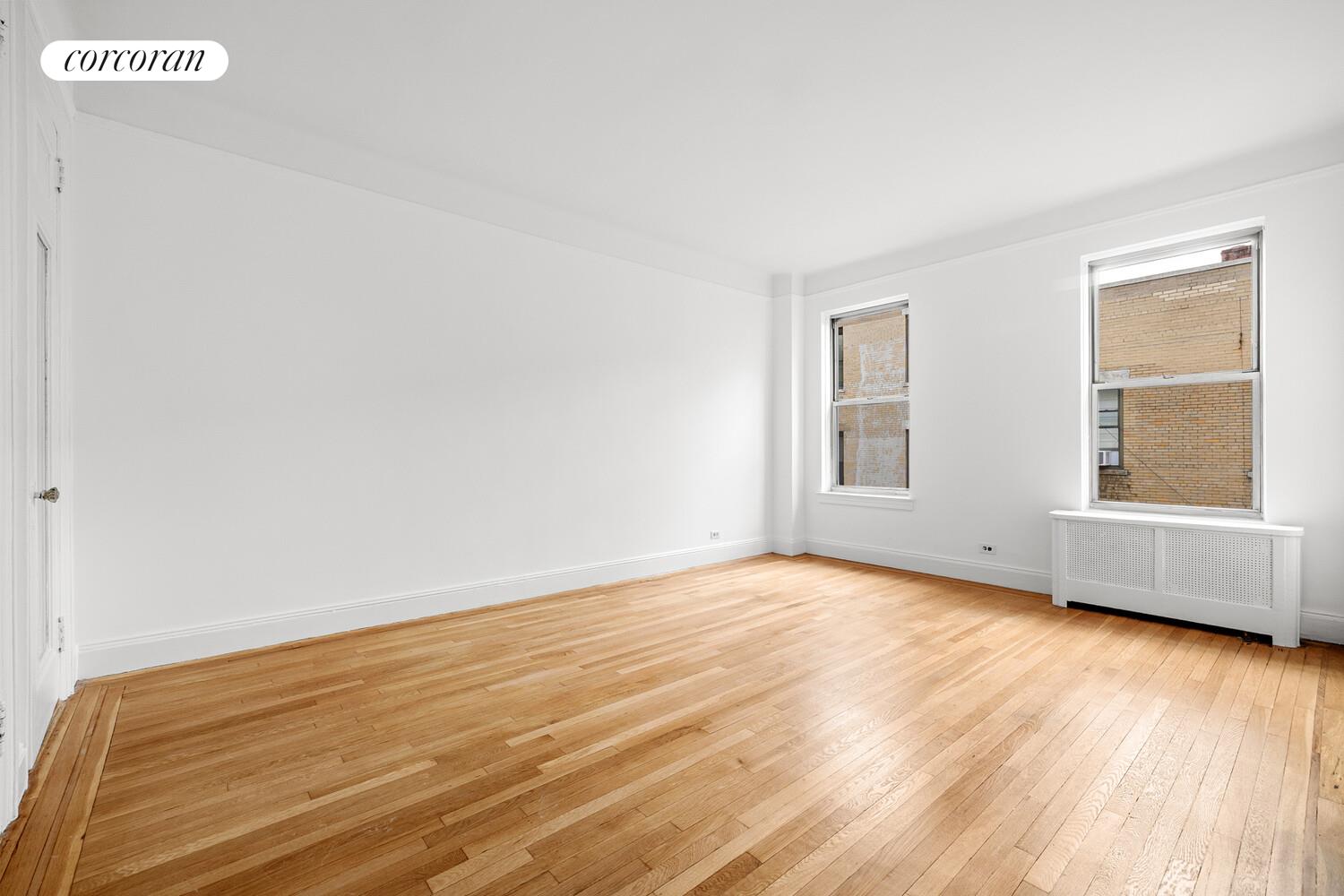 318 West 100th Street, Unit 7D Manhattan, NY 10025 - Photo 10 of 17 a view of an empty room with wooden floor and a window