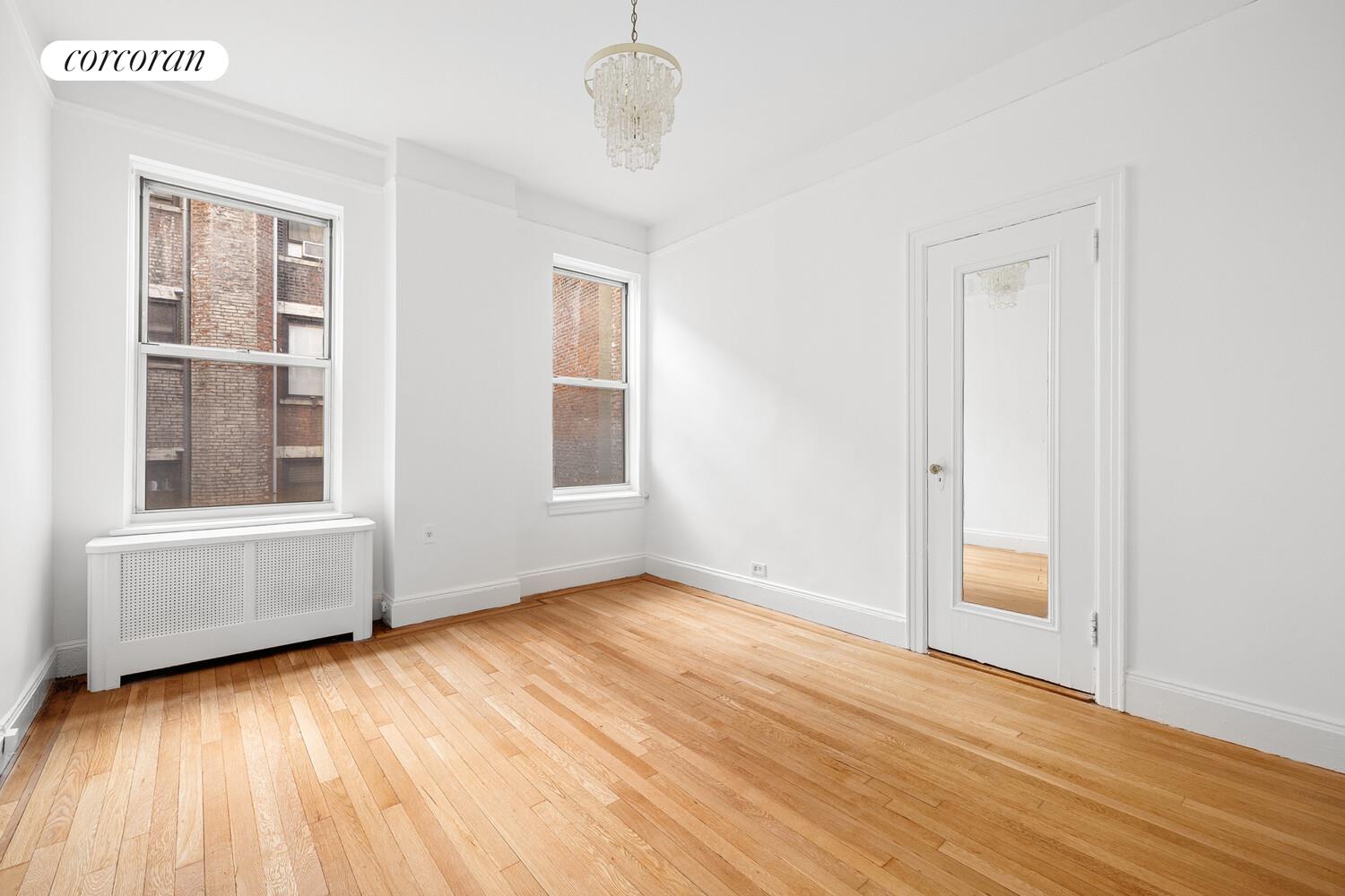 318 West 100th Street, Unit 7D Manhattan, NY 10025 - Photo 11 of 17 a view of an empty room with wooden floor and a window