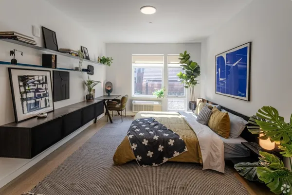 a bedroom with a bed and a potted plant