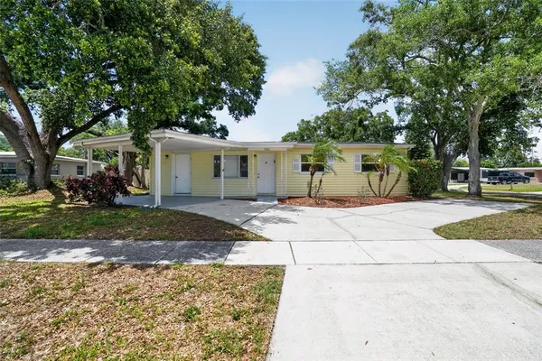 a front view of a house with a yard and trees