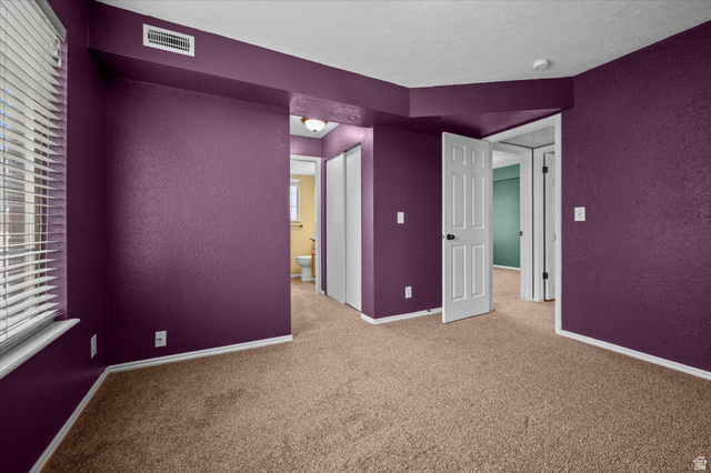 2095 South Main Street, Unit 13 Bountiful, UT 84010 - Photo 13 of 45 Unfurnished room featuring a textured wall, light carpet, healthy amount of natural light, and a textured ceiling
