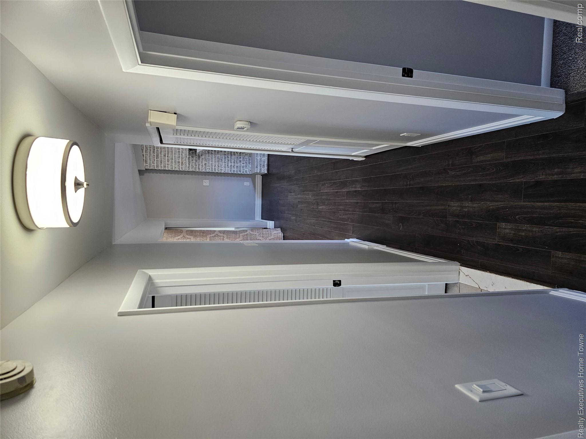 2458 Lindell Road Sterling Heights, MI 48310 - Photo 13 of 17 Hallway featuring dark wood-finish flooring and light gray walls
