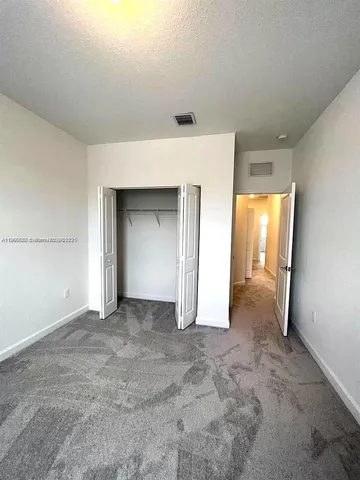 an empty room that has a glass door and closet
