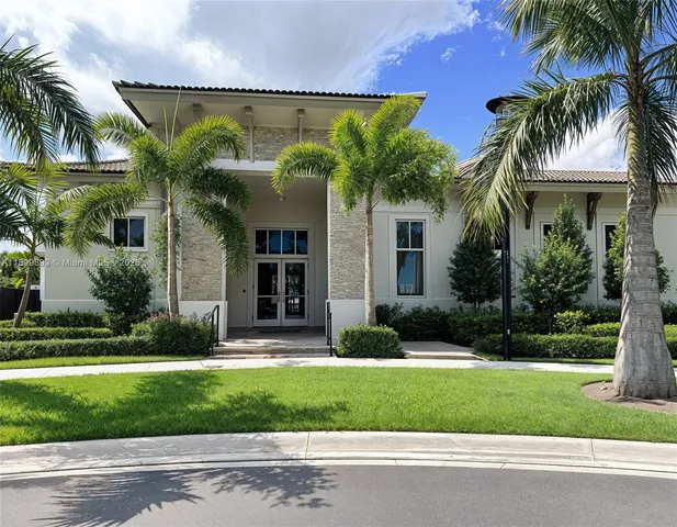 front view of a house with a yard and palm trees