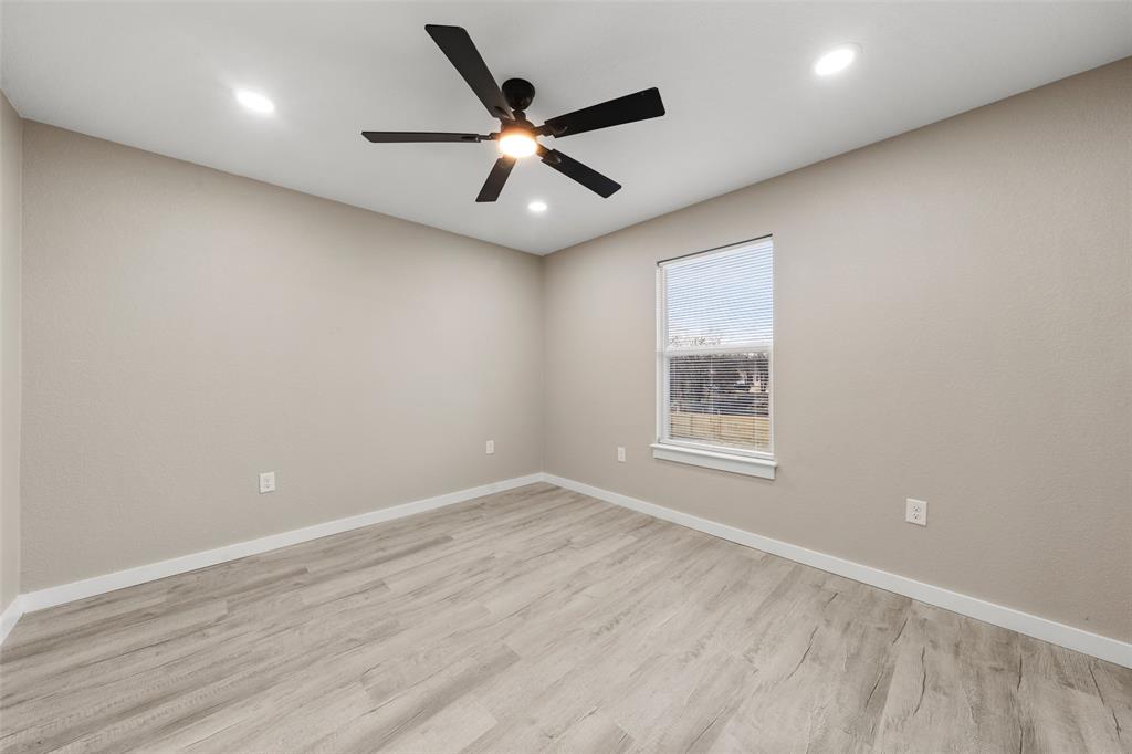 1905 Sanger Avenue Waco, TX 76707 - Photo 15 of 21 an empty room with wooden floor ceiling fan and windows