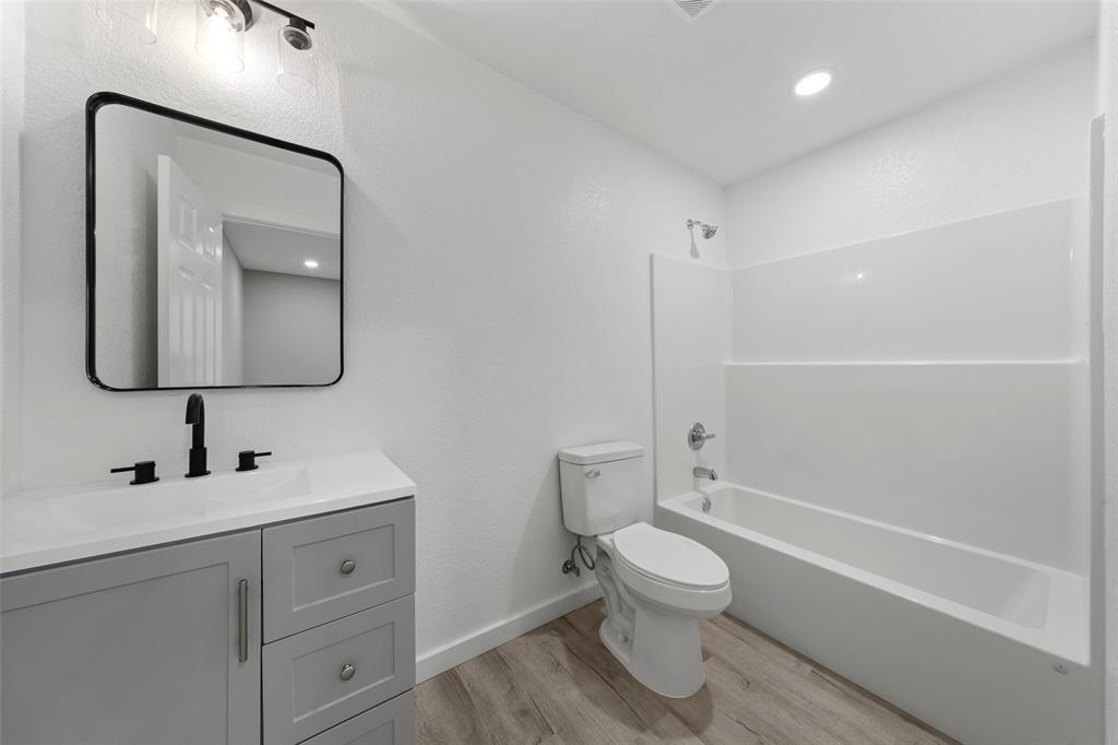 1905 Sanger Avenue Waco, TX 76707 - Photo 18 of 21 a bathroom with a toilet sink a mirror and shower